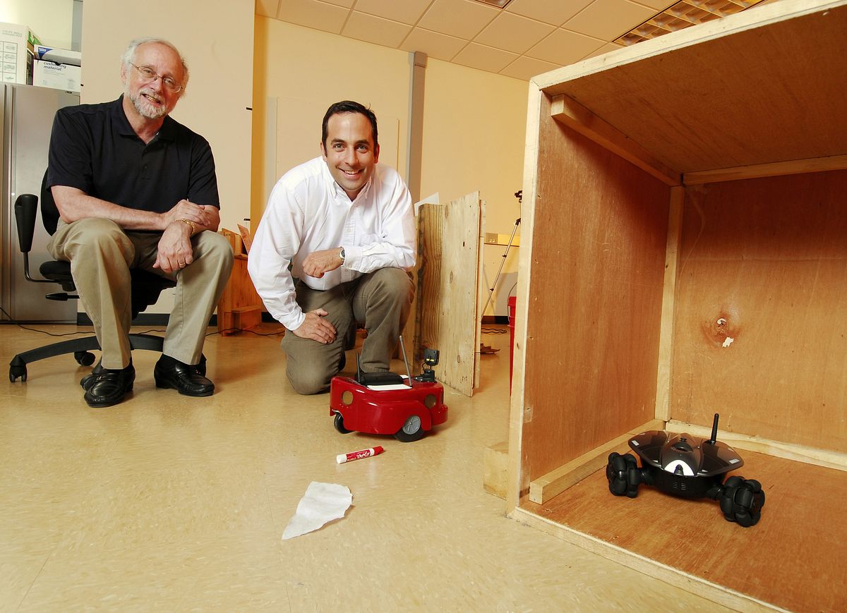 Der schwarze Roboter hat seinen roten Verfolger erfolgreich mit dem umgeworfenen Stift getäuscht. (Foto: Georgia Tech/ Gary Meek)