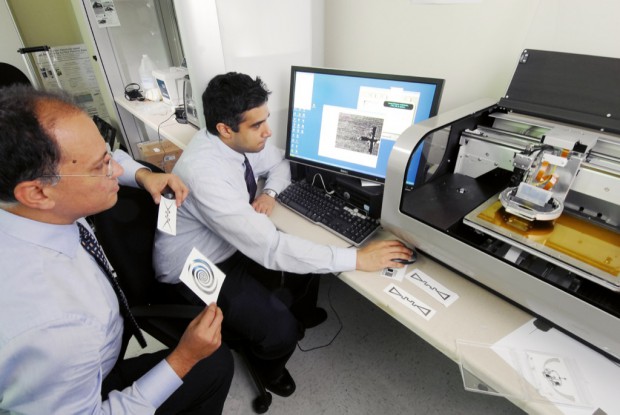 Professor Manos Tentzeris (l.) und Rushi Vyas arbeiten mit dem Tintenstrahldrucker, der Schaltkreise und Antennen drucken kann. (Bild: Georgia Tech)