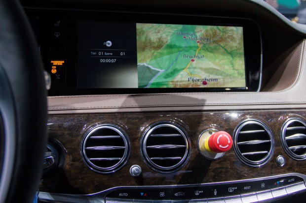 Mit einem Druck auf den roten Knopf kann er im Notfall die Kontrolle über das Auto übernehmen. Auf dem Navigationssystem ist die Route zu erkennen. (Foto: Werner Pluta/Golem.de)
