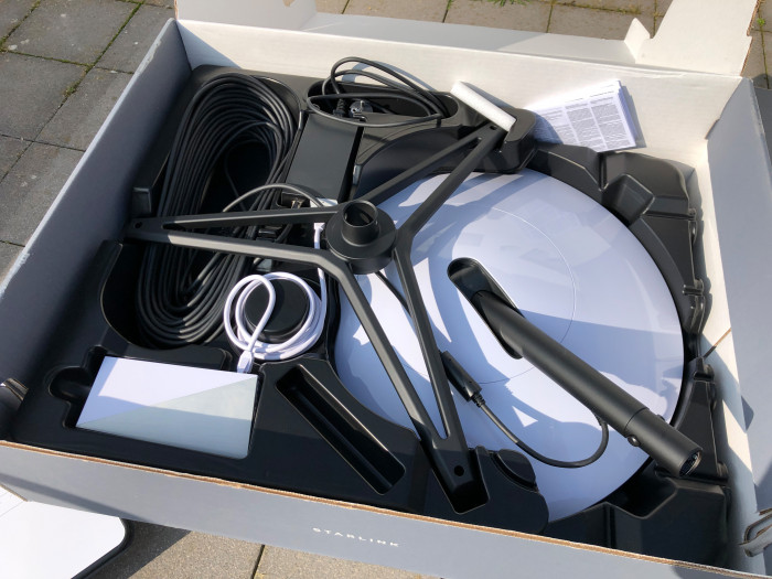 Packungsinhalt: Über allem der Tripod, der bei ausreichend Platz auch angeschraubt werden kann. Links unten in Weiß der Router und oben in Schwarz das Netzteil. (Golem.de-Leser)