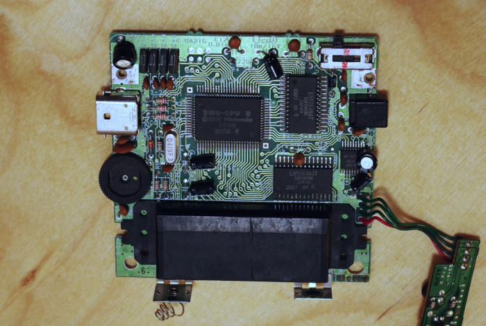 Das Mainboard des Gameboys ist übersichtlich: in der Mitte der Prozessor mit Grafik- und Soundeinheit, rechts oben der Grafikspeicher, darunter der normale RAM. Unten befindet sich der Steckverbinder für die Module. (Bild: Johannes Hiltscher/Golem.de)