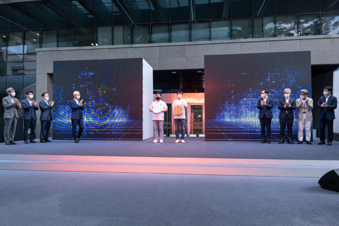 ...ein Tor, zwei Mitarbeiter bringen die erste Box mit fertigen 3-nm-Wafern. (Bild: Samsung)