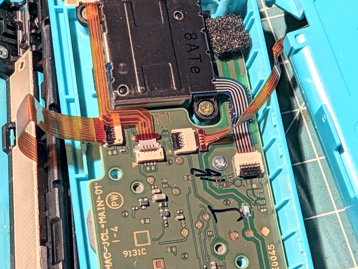 Bevor wir den alten Joystick ausbauen und gegen den neuen austauschen können, müssen wir einige Flachbandkabel entfernen - zunächst das des Mittelteils. (Bild: Tobias Költzsch/Golem.de)