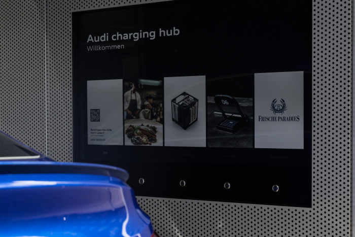 Auf großen Monitoren gibt es Infos rund um die Station. (Foto: Audi)