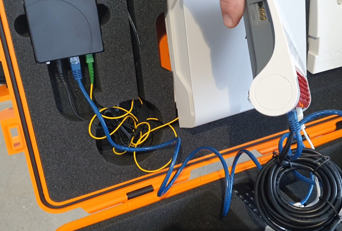Auf der gelben Glasfaser kommt das Internet vom wei&szlig;en H&Uuml;P in den schwarzen ONT herein. &Uuml;ber das blaue LAN-Kabel wird es an die Fritzbox weitergeschickt. &Uuml;ber das schwarze Kabel muss der ONT st&auml;ndig mit Strom versorgt werden. (Bild: Harald Karcher)