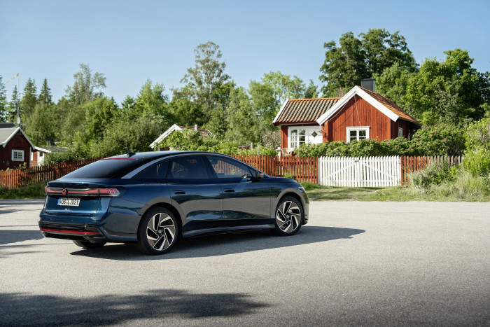 Die Langstreckenlimousine ID.7 Pro S bildet in Aquamarinblau einen schönen Kontrast zu den roten schwedischen Ferienhäusern. (Bild: VW)