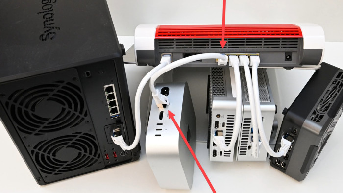 Mittig hängt ein silbriger Mac mini M4 mit 10-Gig-Sonderausstattung am gelben 10G-LAN-Port der roten Fritzbox 4690. (Bild: Harald Karcher)
