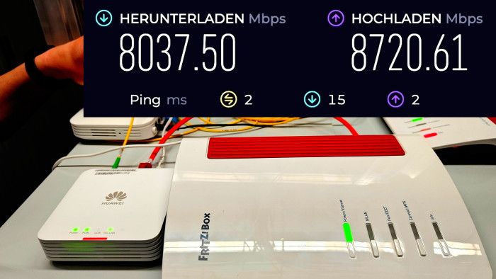 Internet-Durchsatzwerte (oben) mit der 10-Gig-Fritzbox 4690 von AVM (rechts) hinter dem 10-Gig-Glasfaser-ONT-Modem von Huawei (links vorne) (Bild: Harald Karcher)