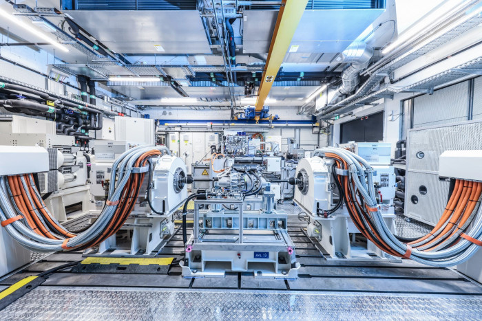 Das ist ein Testauto: Man erkennt im Hochvolt-Prüfstand den E-Motor in der Mitte. Die Achse führt auf beiden Seiten in Kästen, die Räder und Bremsen simulieren. Die Batterie befindet sich aus Sicherheitsgründen ein Stockwerk tiefer. (Bild: Porsche)