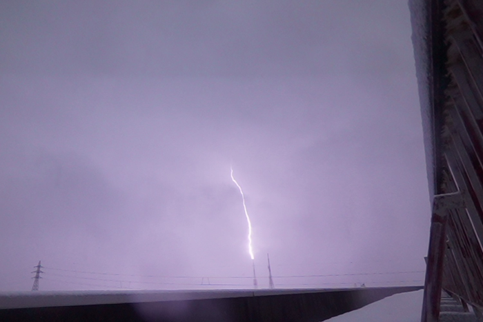 Ein Blitzkanal schlägt von einem Fernsehturm nach oben. Beim Zusammentreffen mit dem von der Wolke nach unten ausschlagenden Blitzkanal entsteht dann nach unten gerichtete Gammastrahlung. (Bild: Yuuki Wada / U. Osaka)