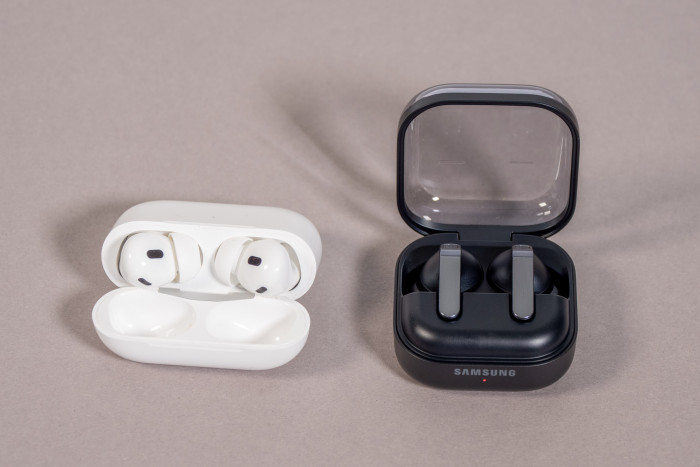 Links die Airpods Pro 2 im Ladeetui, rechts daneben die Galaxy Buds 4 Pro im Ladeetui (Bild: Martin Wolf/Golem)