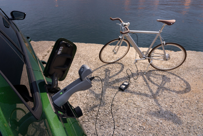 V2L: Der Opel Astra Sports Tourer gibt über einen Adapter im Ladeanschluss Energie an externe Geräte ab, beispielsweise an ein E-Bike. (Bild: Opel)