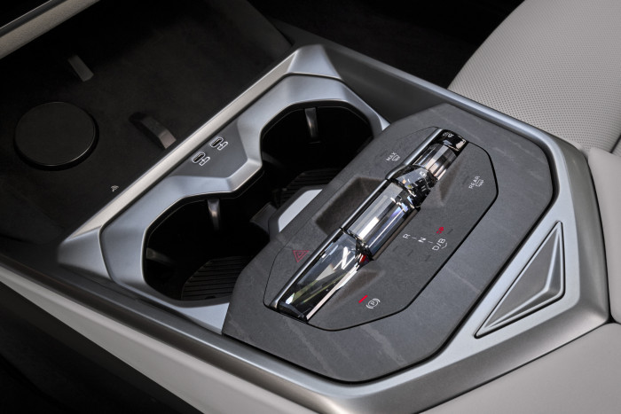 In der Mittelkonsole befinden sich neben Getränkehaltern und Ladeschalen für Smartphones noch der Fahrwahlhebel. (Foto: BMW)