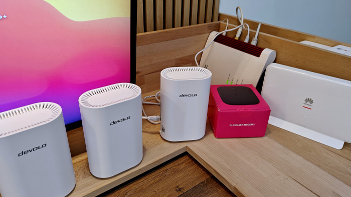 Die drei weißen Router des Devolo Wi-Fi 7 Mesh Sets BE 6500 können zwar das WLAN einer Fritzbox verlängern, aber das Internet auch direkt aus dem Telekom-Magenta-Glasfasermodem-2-ONT beziehen, ohne Fritzbox dazwischen. (Bild: Harald Karcher)