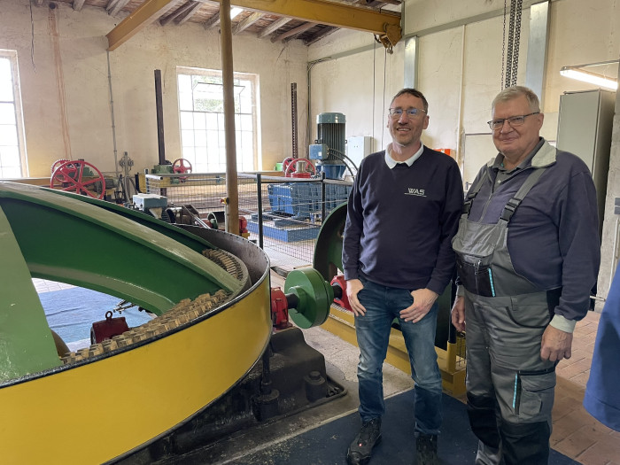 Anno Trost, Betriebsleiter von Wasserkraftanlagenbau Stein, und Jörg Richter, Wasserkraftanlagenbetreiber sowie ehemaliger Präsident des Wasserkraftverbandes Mitteldeutschland, am 100 Jahre alten, weiterhin genutzten Schaufelrad in Lunzenau, Sachsen (Quelle: Golem/Mario Petzold)